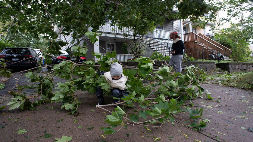 Milo Reichert helps his neigbour clear some branches on MacDonald Street following the passing of Hurricane Fiona, later downgraded to a post-tropical storm, in Halifax, Nova Scotia, Canada September 24, 2022. REUTERS/Ingrid Bulmer