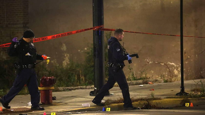 Investigators work at a scene where police said as many as 14 people were shot on Oct. 31, 2022, in Chicago, Illinois. Scott Olson/Getty Images