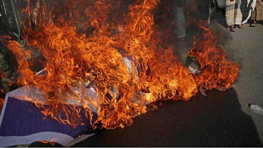 Iranpress: Yemenis set bin Zayed picture, Israeli flag in fire