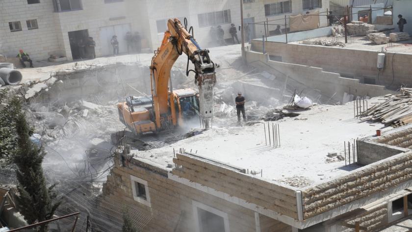 Iranpress: Israeli Bulldozers tear down a Palestinian building in Al-Quds