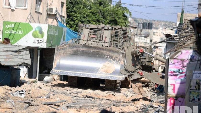 Iranpress: Israeli bulldozer destroys Jenin street during raid as some 3,000 flee refugee camp