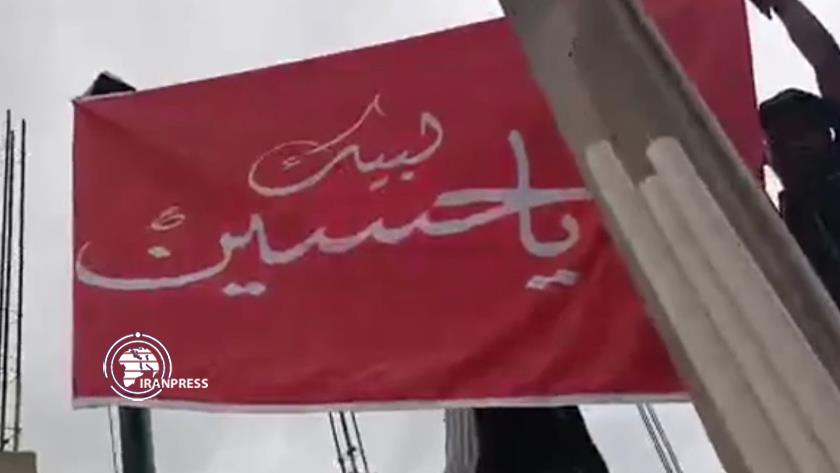 Iranpress: Ghanaians mourners renew the flag of Imam Hussein 