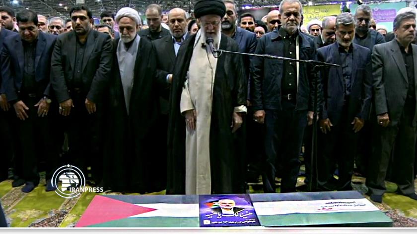 Iranpress: Leader Leads Mass Prayer on Body of Martyr Haniyah